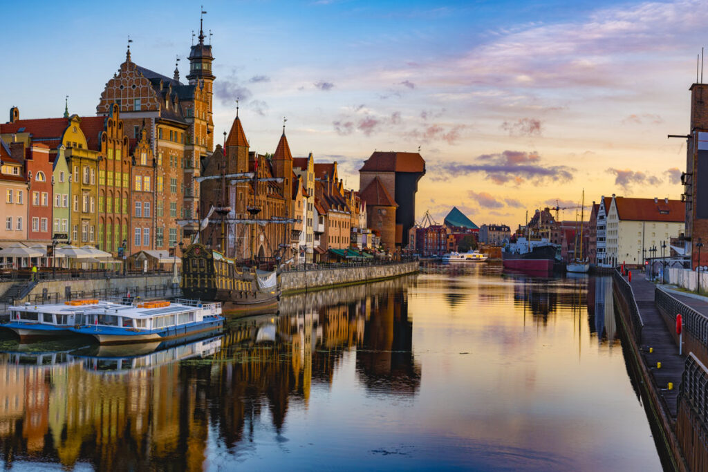 Gdansk eski liman kanalı boyunca gün batımında tarihi binalar ve yelkenli gemi