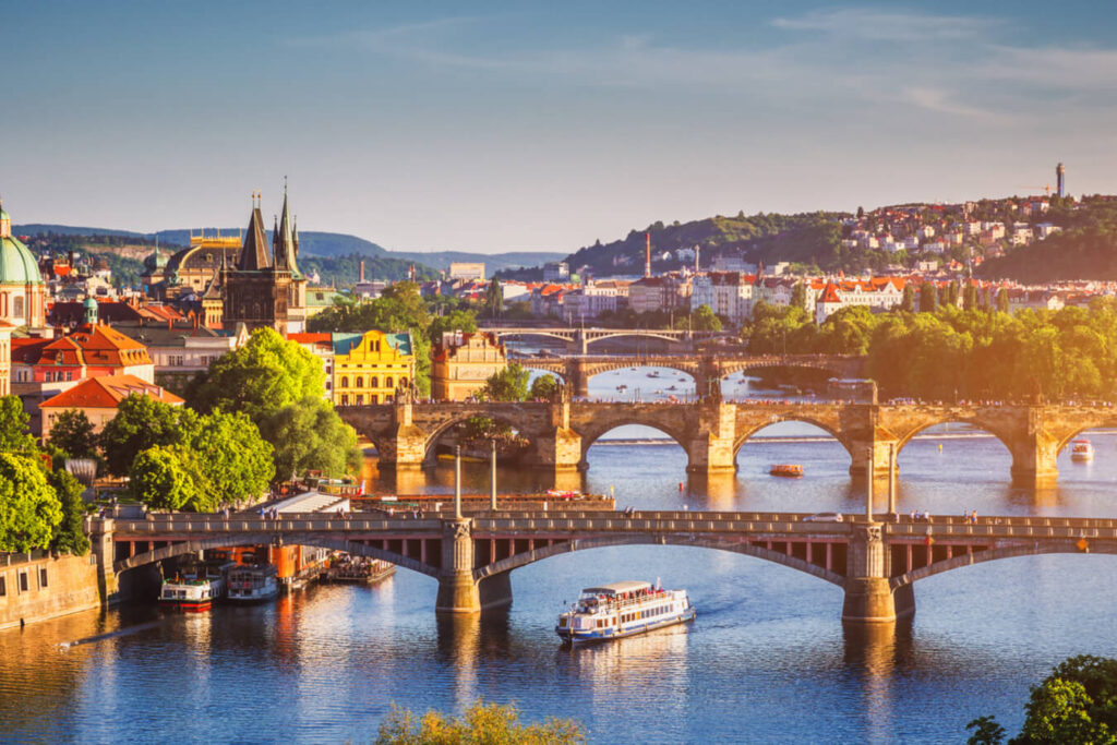 Prag'da Vltava Nehri üzerindeki köprüler ve tekneyle gün batımı manzarası