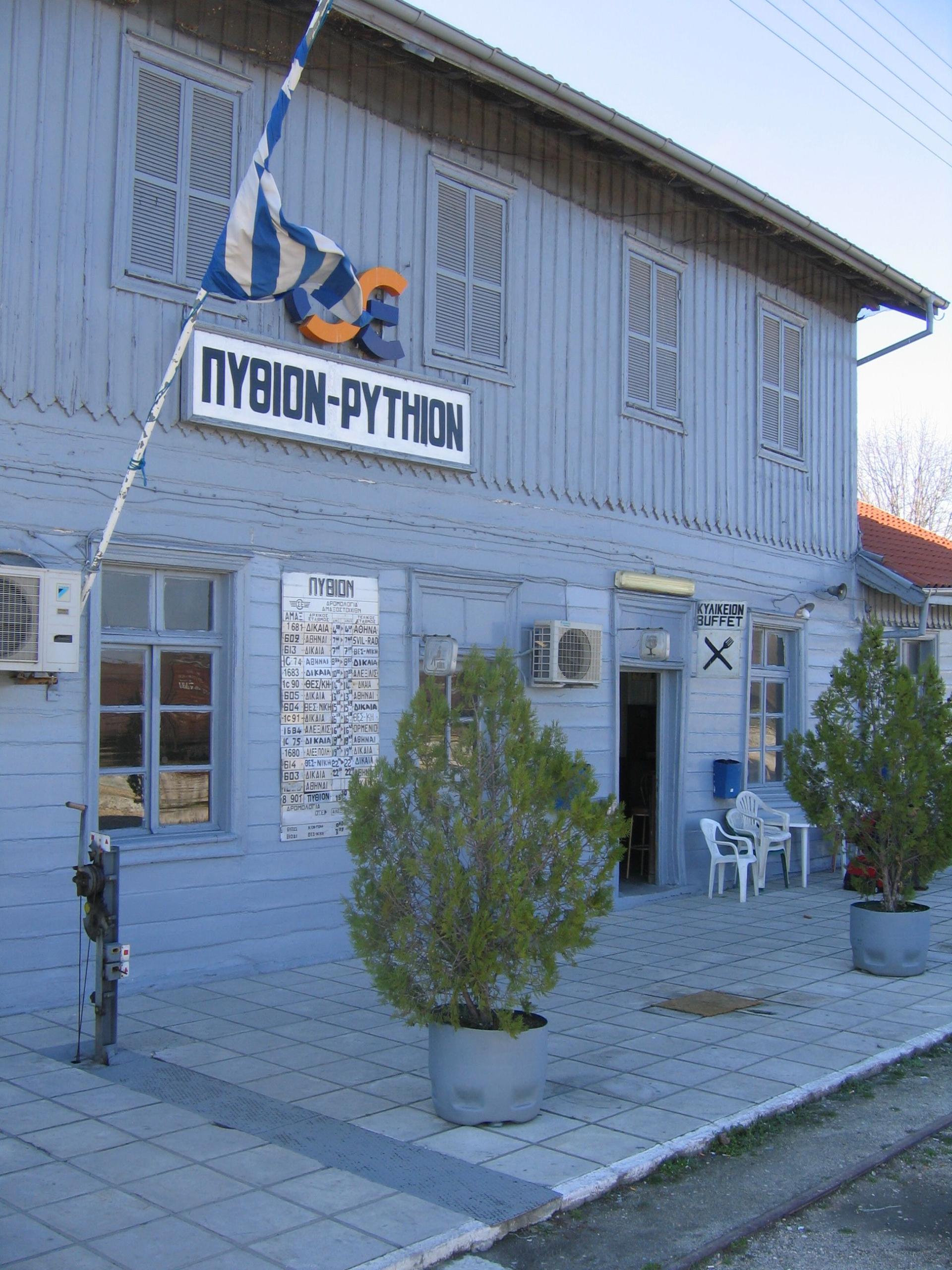 Yunanistan'da ahşap Pythion tren istasyonu binası, tarife panosu ve Yunan bayrağı