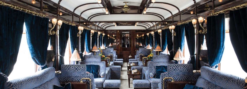 Orient Express'in mavi kadife perdeli, koltuklu lüks tarihi salon vagonunun iç görünümü