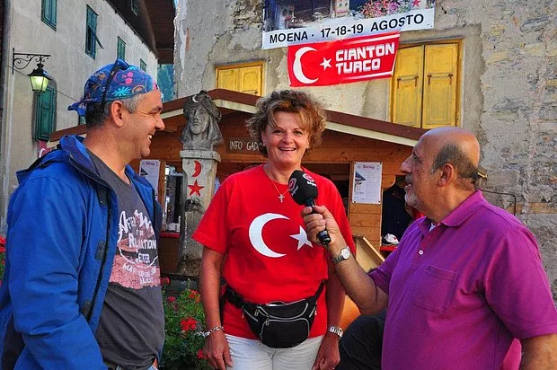Moena'daki El Turco festivalinde Türk bayraklı tişörtle röportaj veren kadın