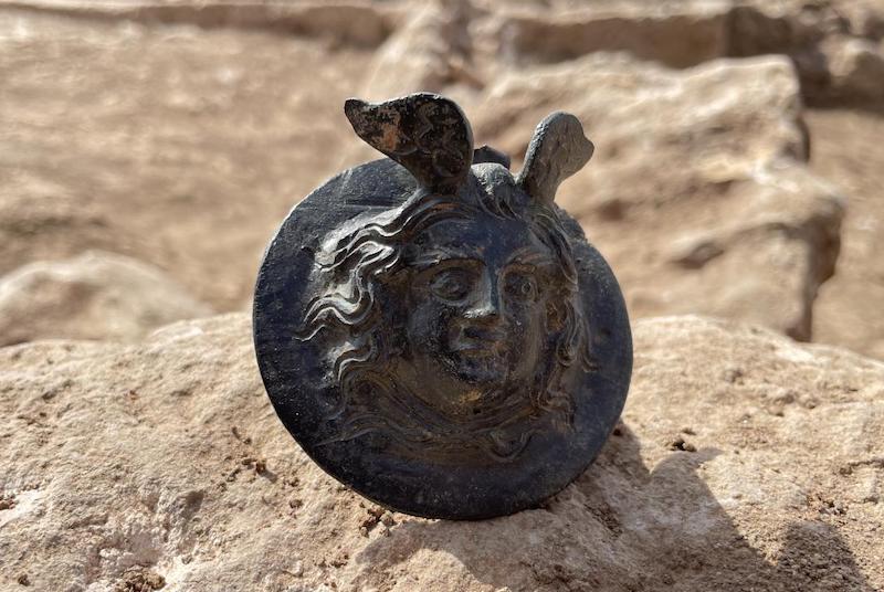 Taş üzerinde duran kadın yüzü kabartmalı antik bronz madalyon